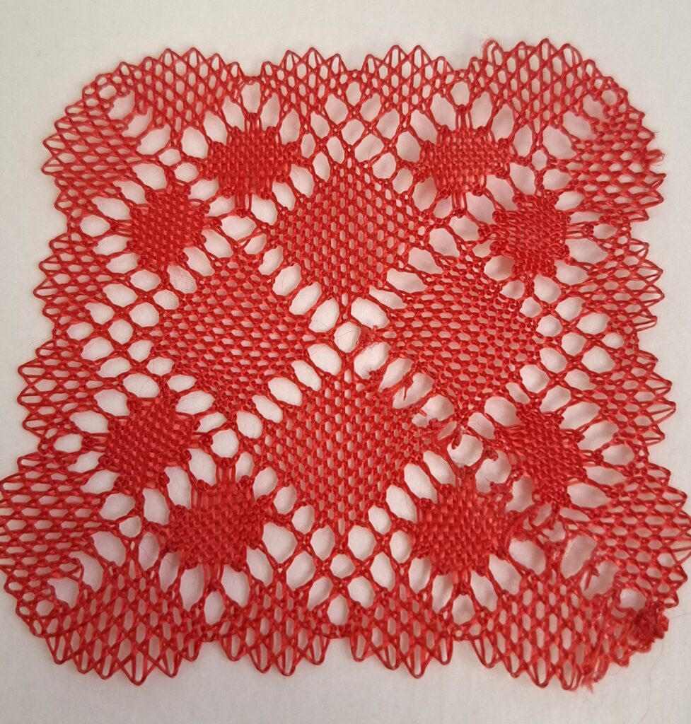 Dentelle Fait au fuseau en fil rouge, fabrication lors d'ateliers créatifs