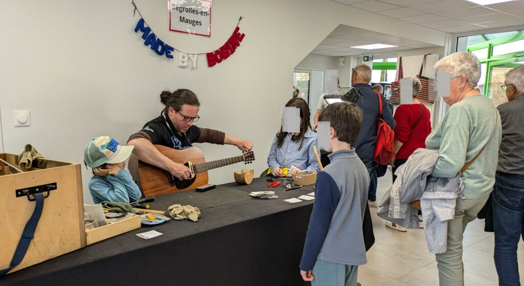 accord d'une guitare par christophe valençon lors des jema 2025 à la manufacture de tressage 
